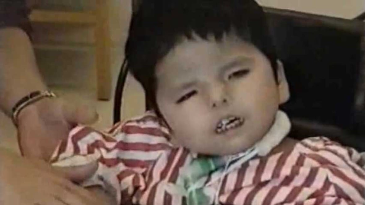 A close-up of a young child with short, dark hair.
