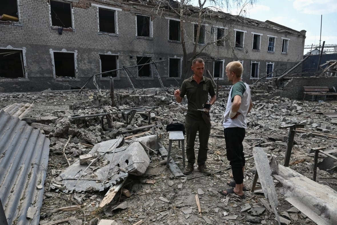 A serviceman speaks with a prisoner at the site of the penal colony hit by a Russian air strike, amid Russia's attack on Ukraine, in Zaporizhzhia region, Ukraine July 29, 2025. 