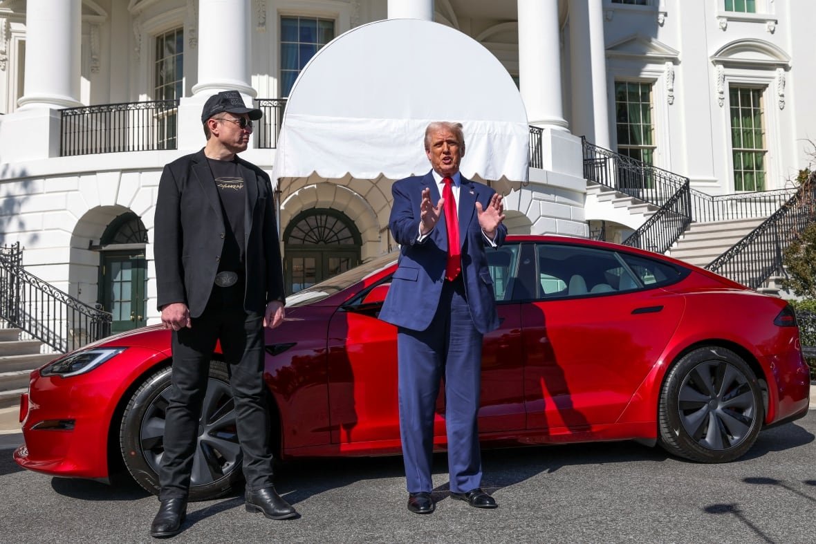U.S. President Donald Trump talks to the media next to Tesla CEO Elon Musk, with a Tesla car in the background, at the White House in Washington, D.C., U.S., March 11, 2025.