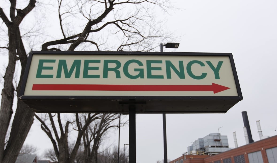A sign reads "emergency" outside a hospital building.