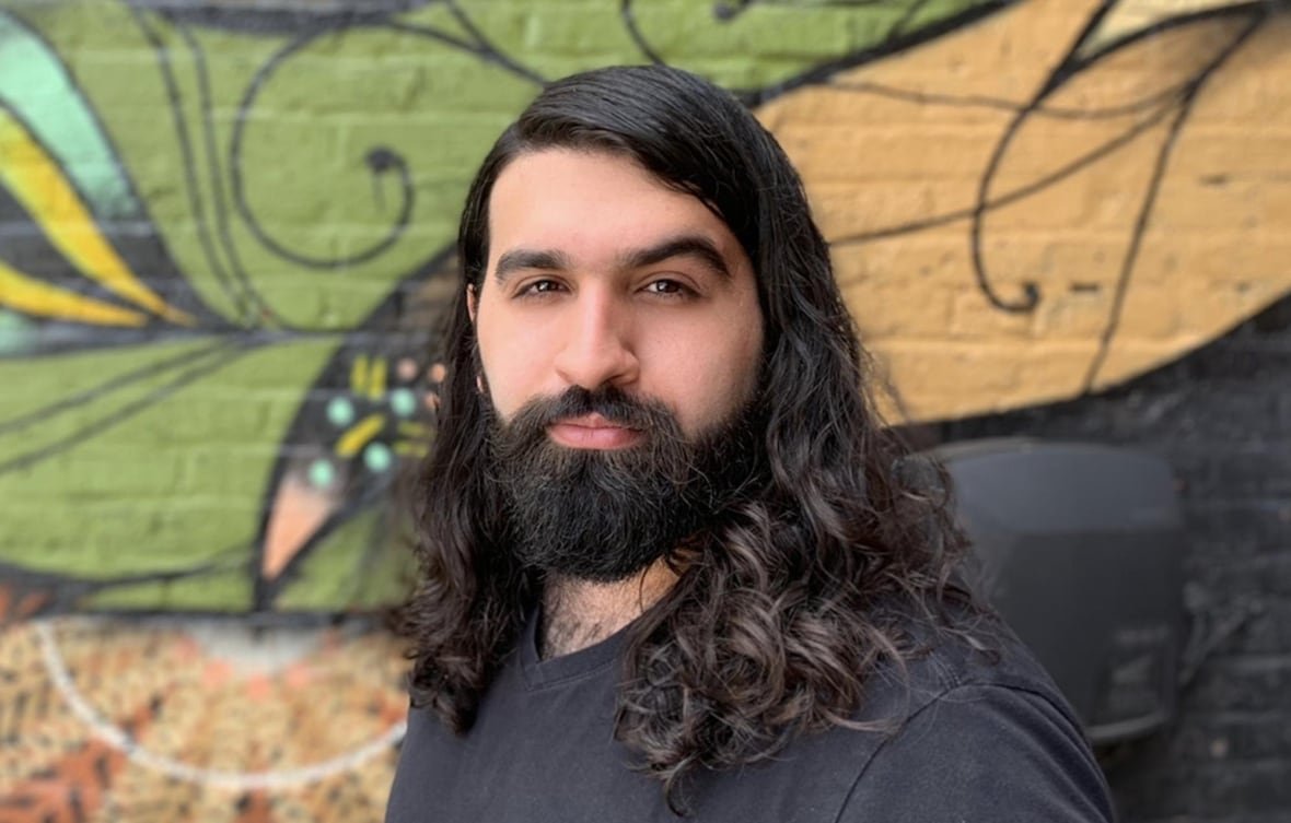 Person with a beard and shoulder-length hair.  