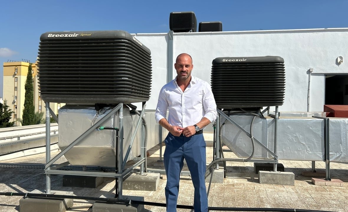 A man stands next to machines installed on the roof of a school in Seville.