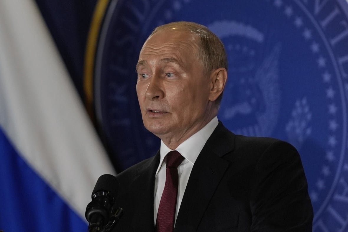 A man in a suit stands at a podium.