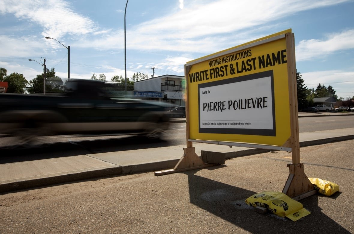 A yellow sign on a sidewalk shows an example of a write-in ballot.