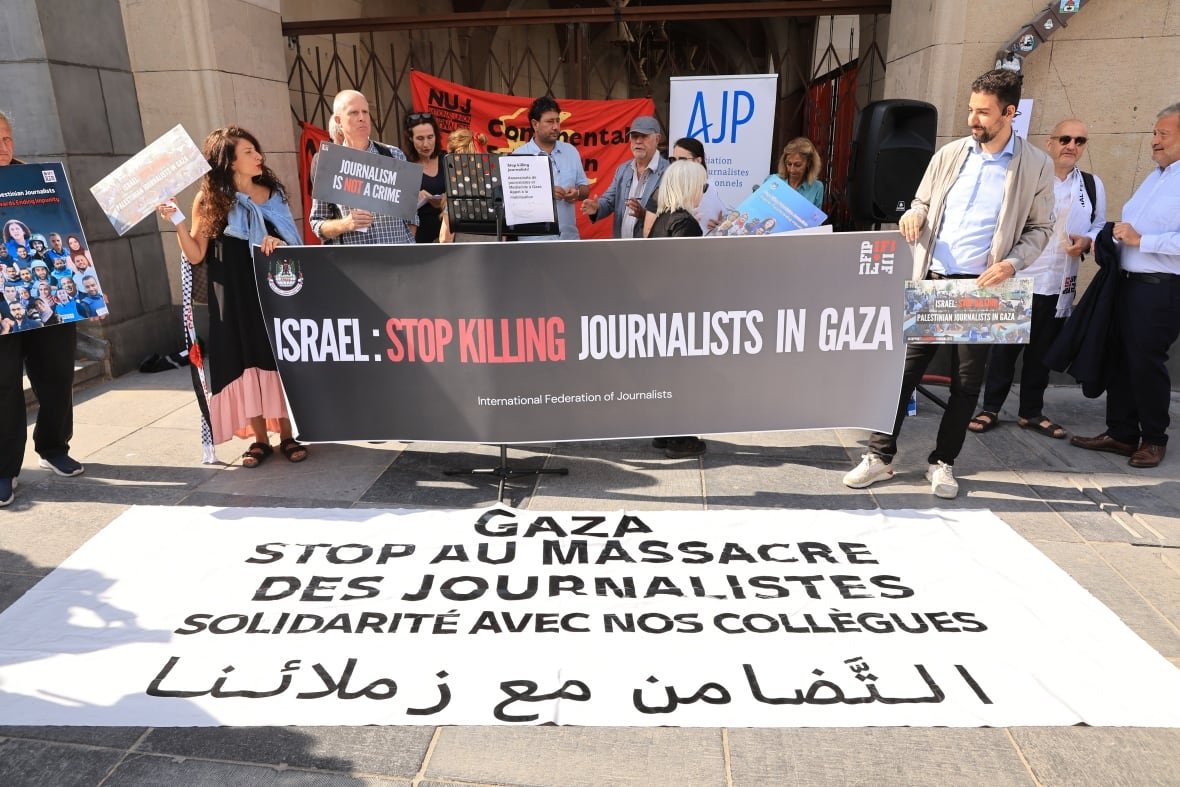 A group of people hold a banner that states 'Israel: Stop Killing Journalists in Gaza'