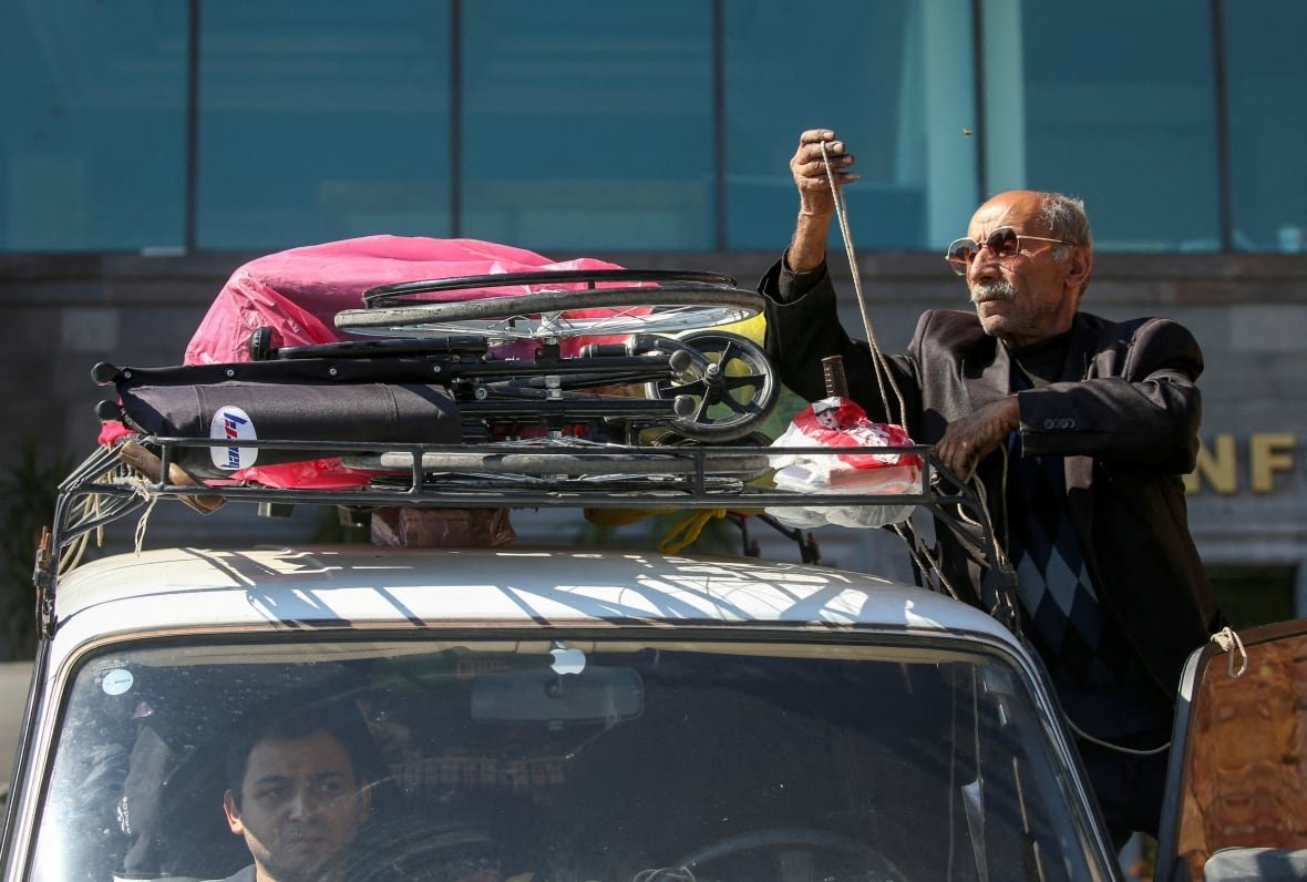 A man loading up a car. 