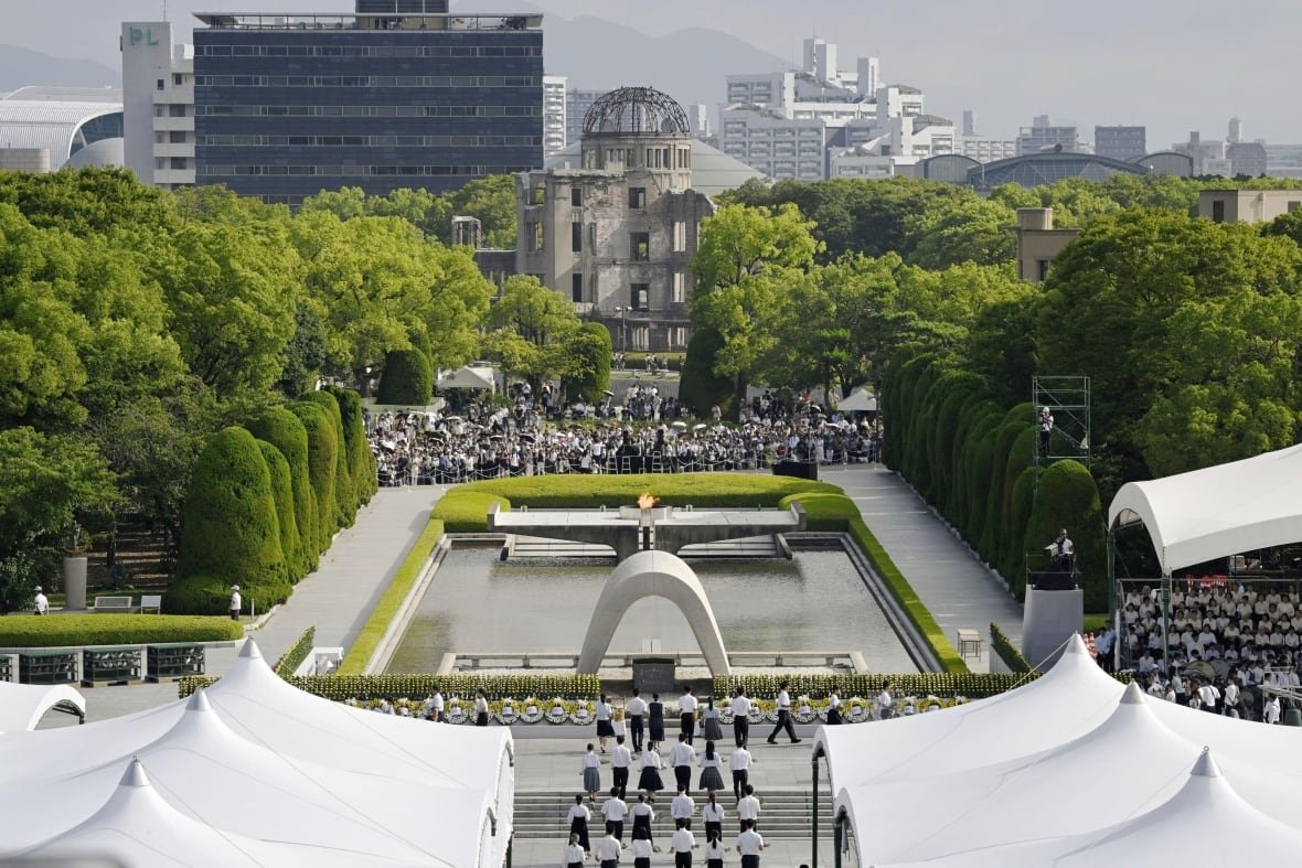 A large gathering of people in an outdoor public square is shown from an aerial view.