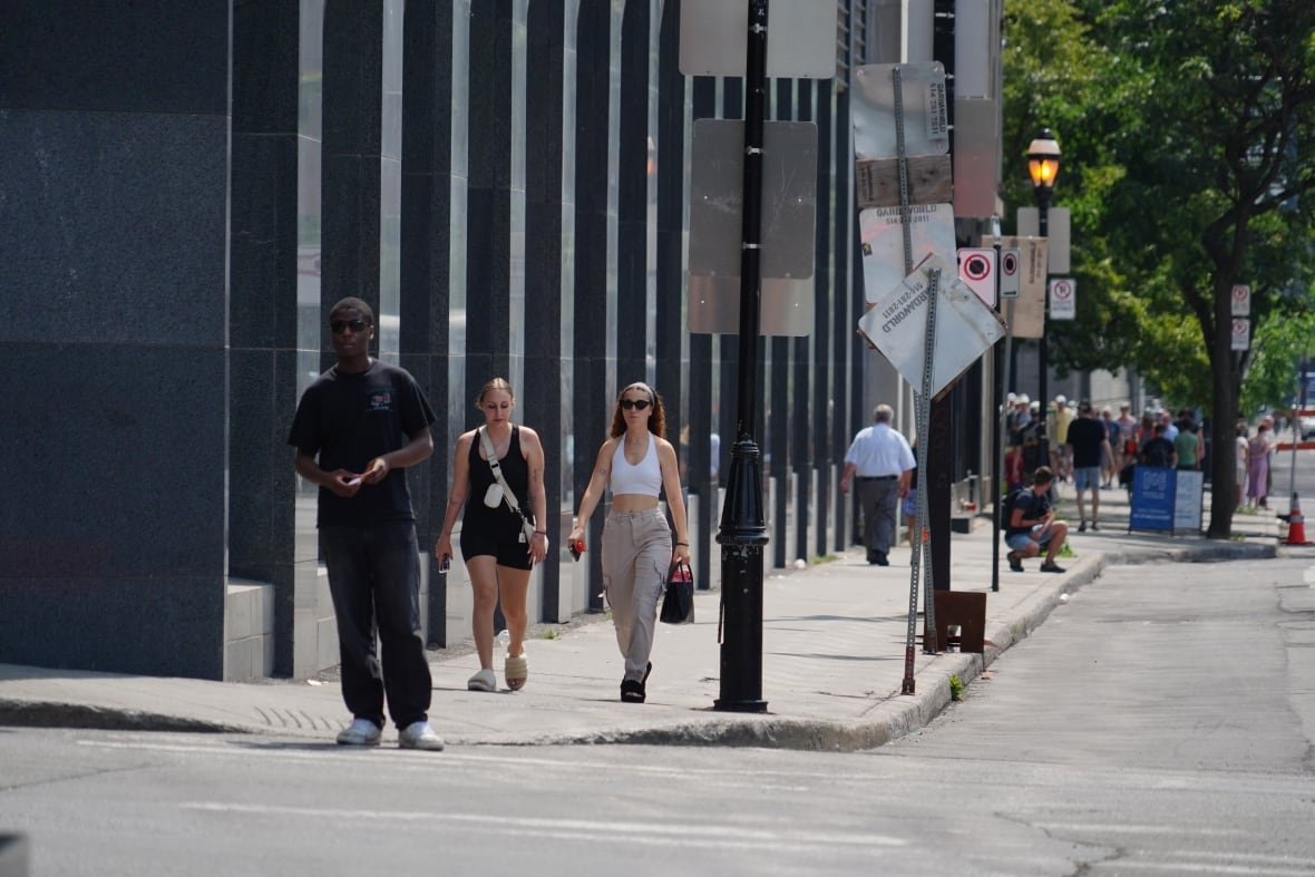 Pedestrians walk in  Old Montreal on a sunny day.