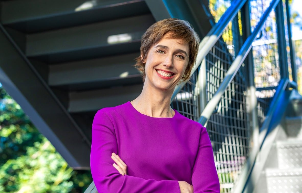 Image of a smiling woman in a magenta sweater 