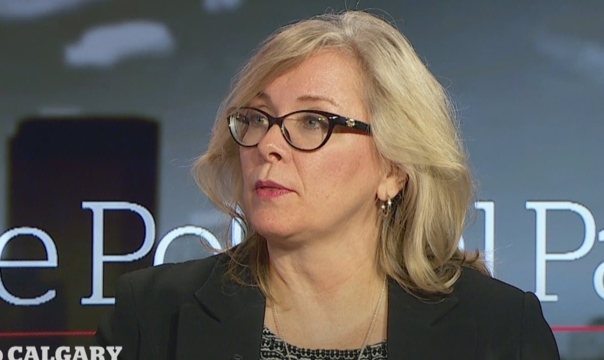 A woman with glasses prepares to say something.