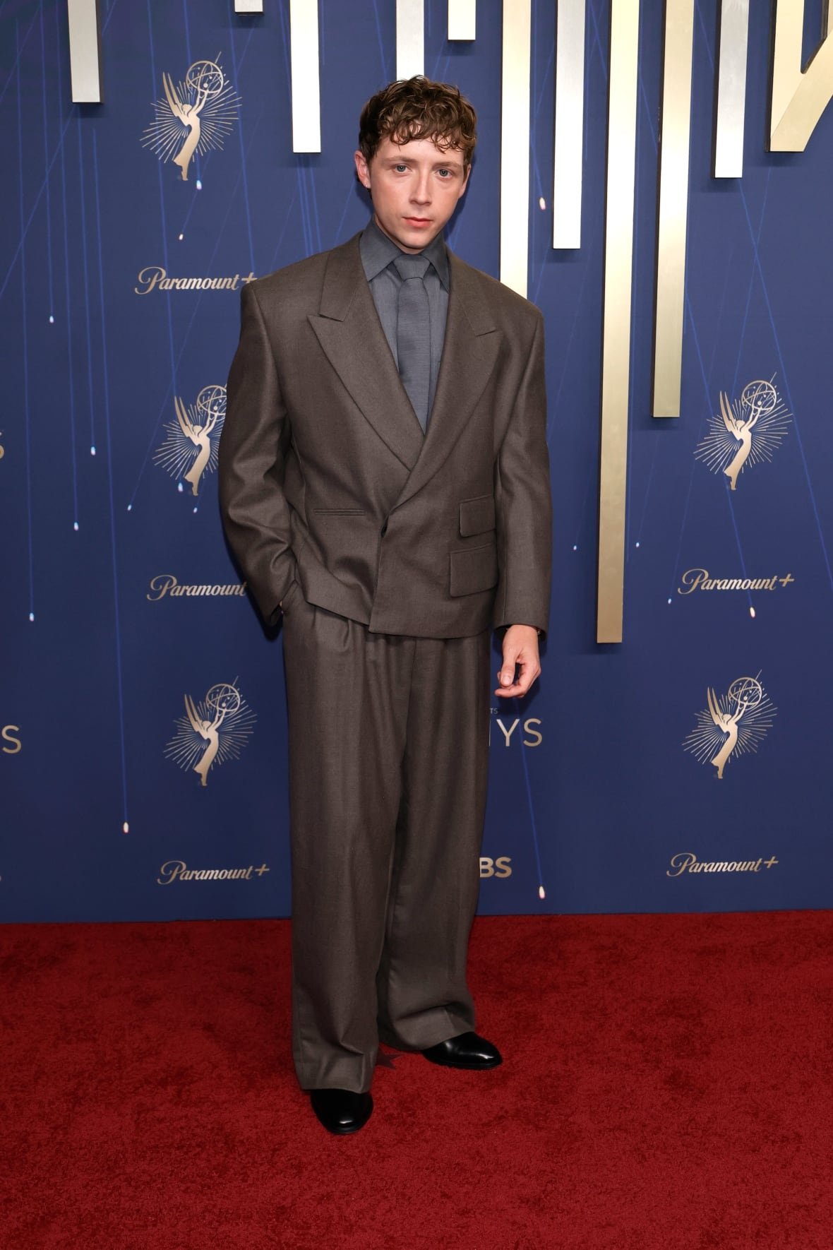 A man poses for a photo wearing a suit. 