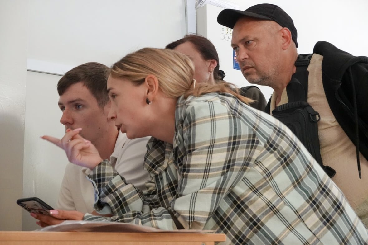 The family of missing Ukrainian soldier Vladyslav Kharkov examine pictures of recovered personal items from fallen soldiers in an effort to figure out if Kharkov is among the tens of thousands of Ukraine's war dead.