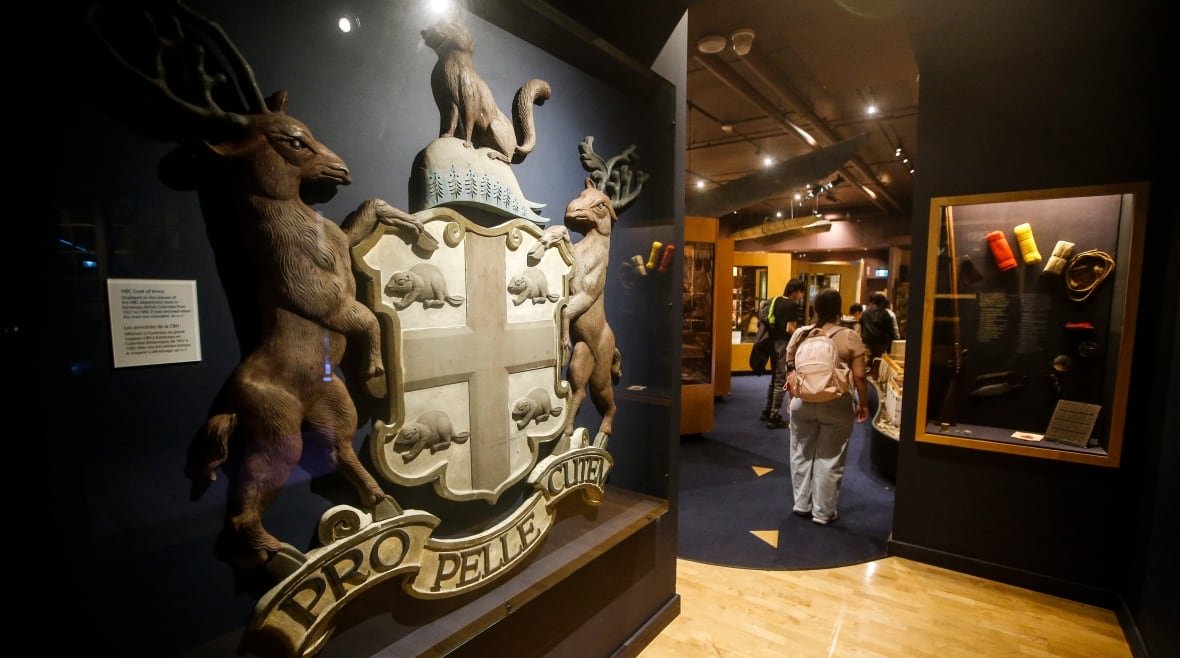 A woman walks through a museum gallery.