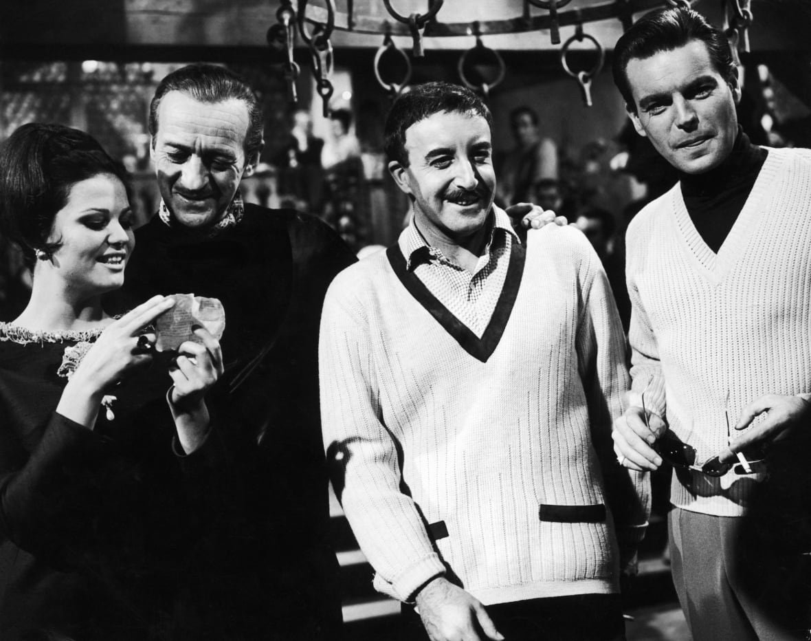 A woman and three men are shown in a black and white photograph that appears decades old.