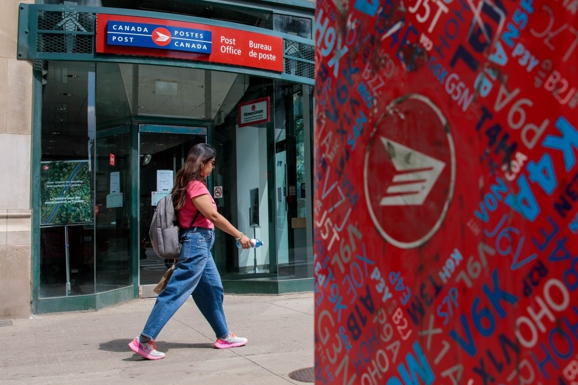 A person walks by a mailbox.