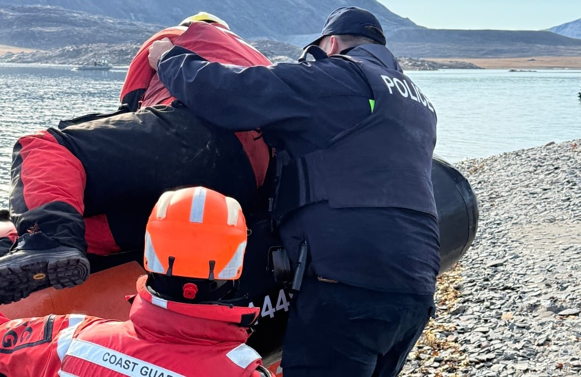 Two uniformed men, both with their backs to the camera, grapple with a third man.