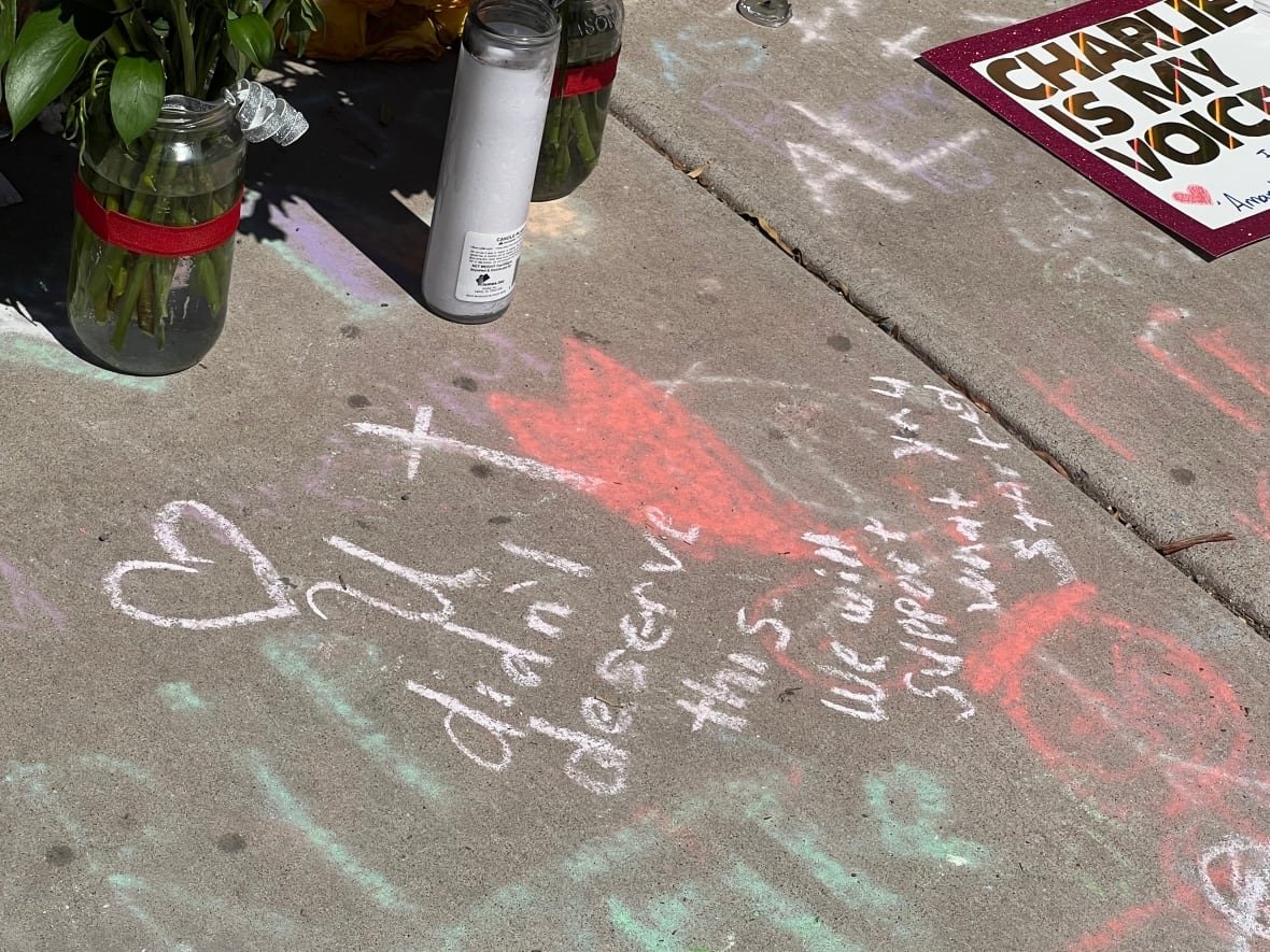 Message in chalk on the sidewalk of the makeshift memorial in front of Turning Point USA headquarters. It reads: "You didn't deserve this. We will support what you started."