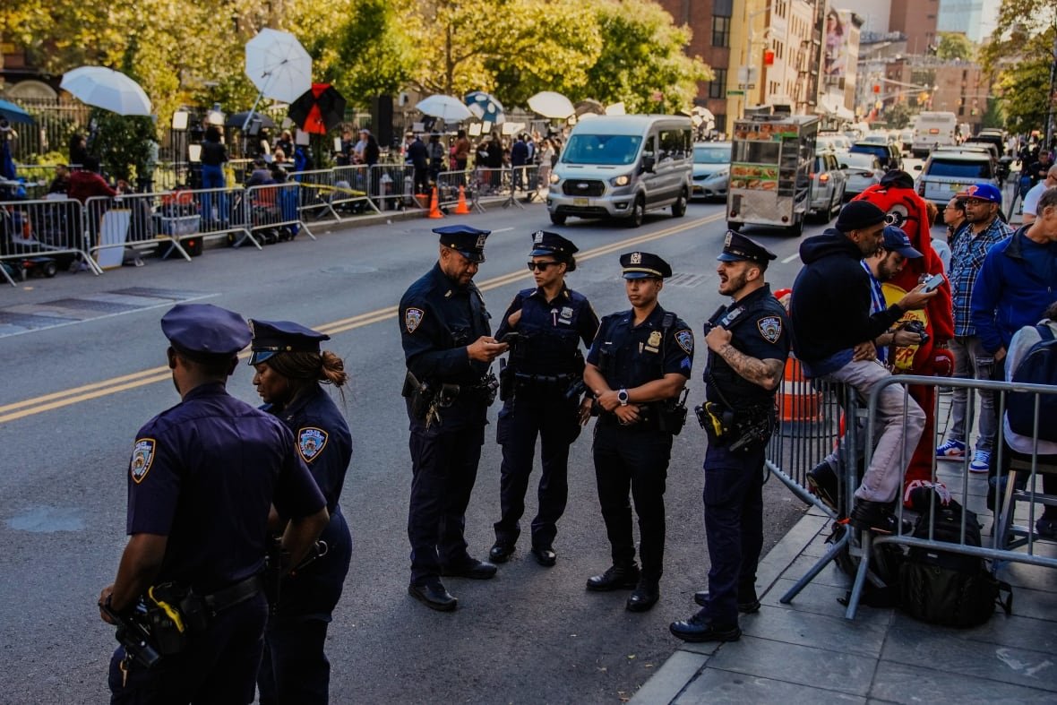 A group of police officers stand on a street.