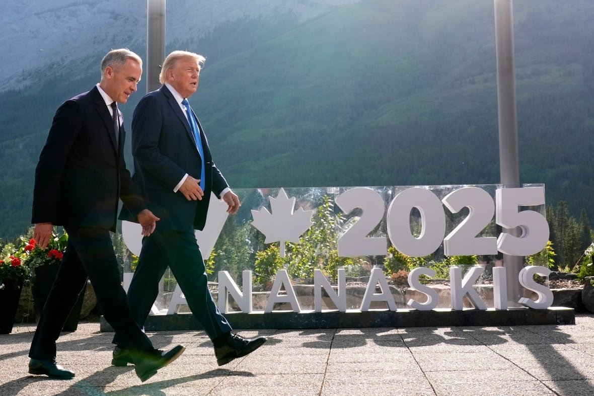 Two men in suits walk outside.