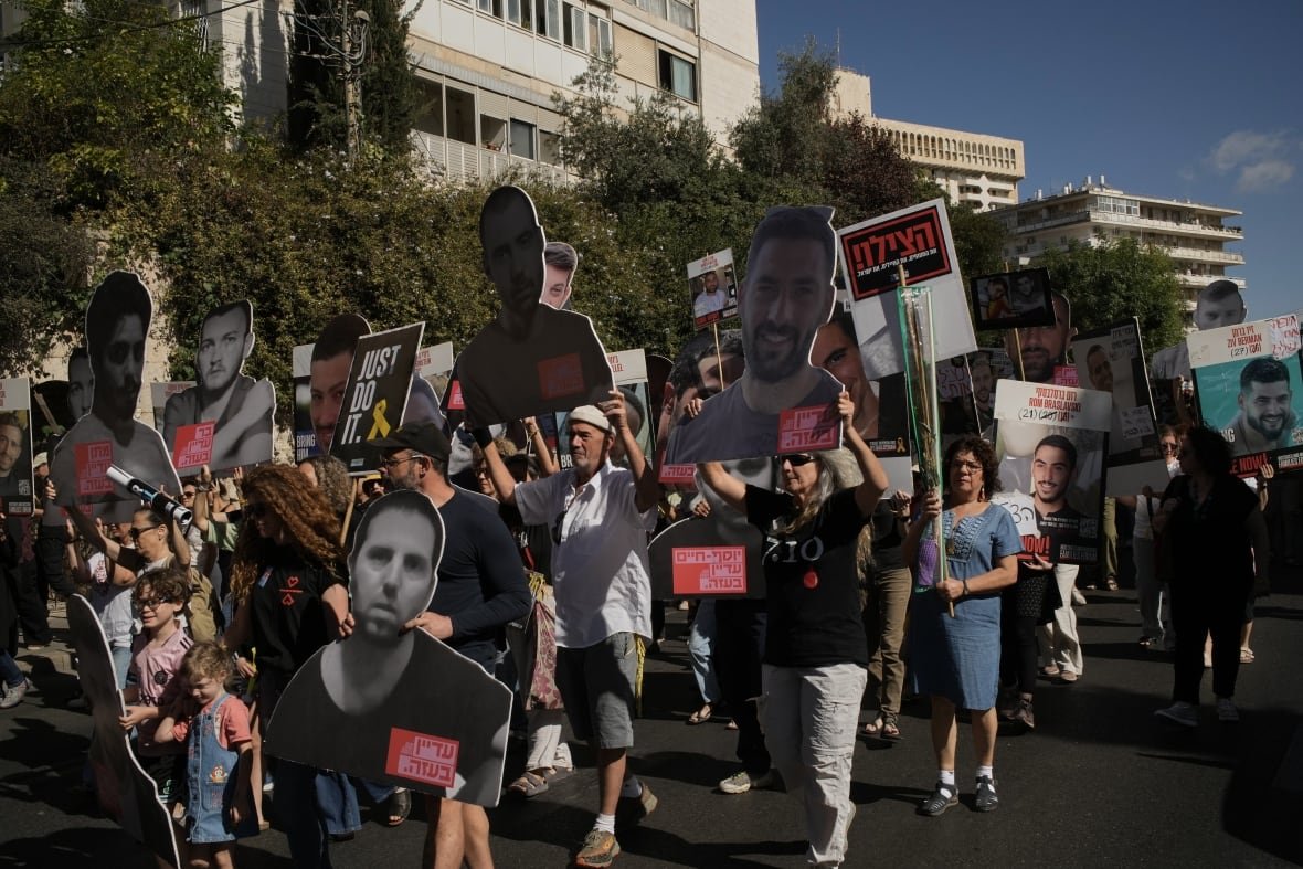 People march in a crowd holding signs.
