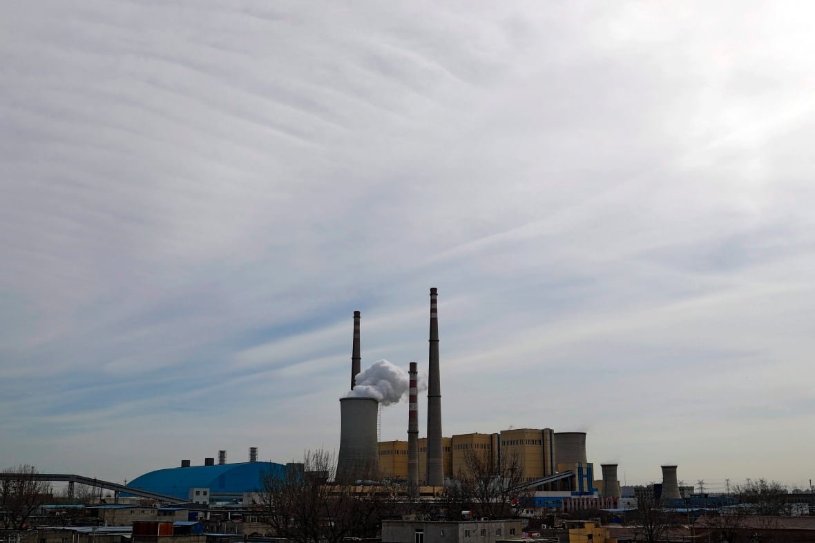 FILE - In this Feb. 28, 2017 file photo, white smoke and steam rise from the China Huaneng Group's Beijing power plant that was the last coal-fired plant to shut down on March 18, 2017 as the Chinese capital convert to clean energy like thermal power. The global fleet of coal-fired power plants is projected to begin shrinking by 2022 as plant retirements outpace new construction, according to a new report that warns the heavily-polluting fuel's decline may not come quickly enough to meet international emission reduction goals intended to stave off climate change. (AP Photo/Andy Wong, File)
