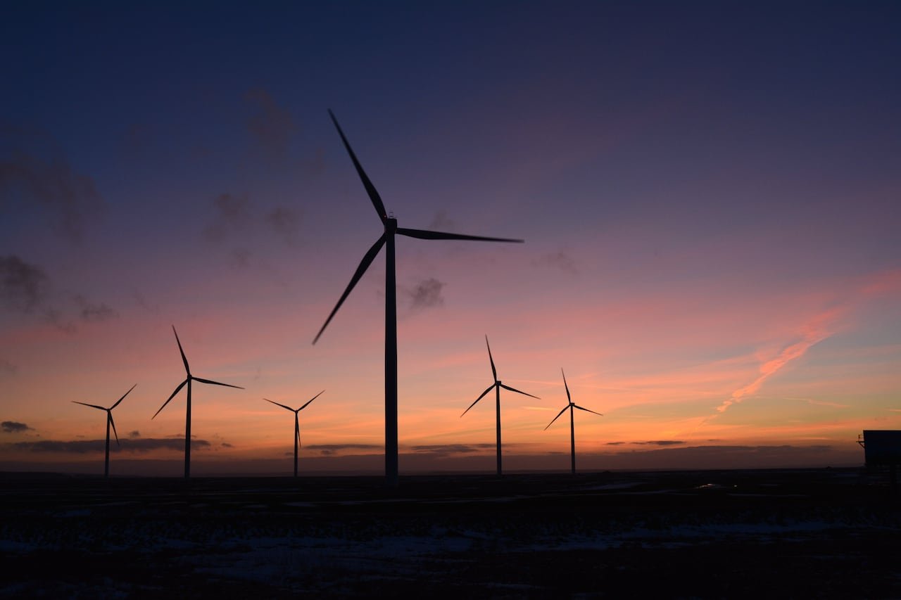 Wind turbines seen against a sunset