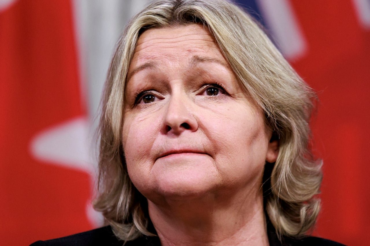 A women with blonde hair looks out into the distance.