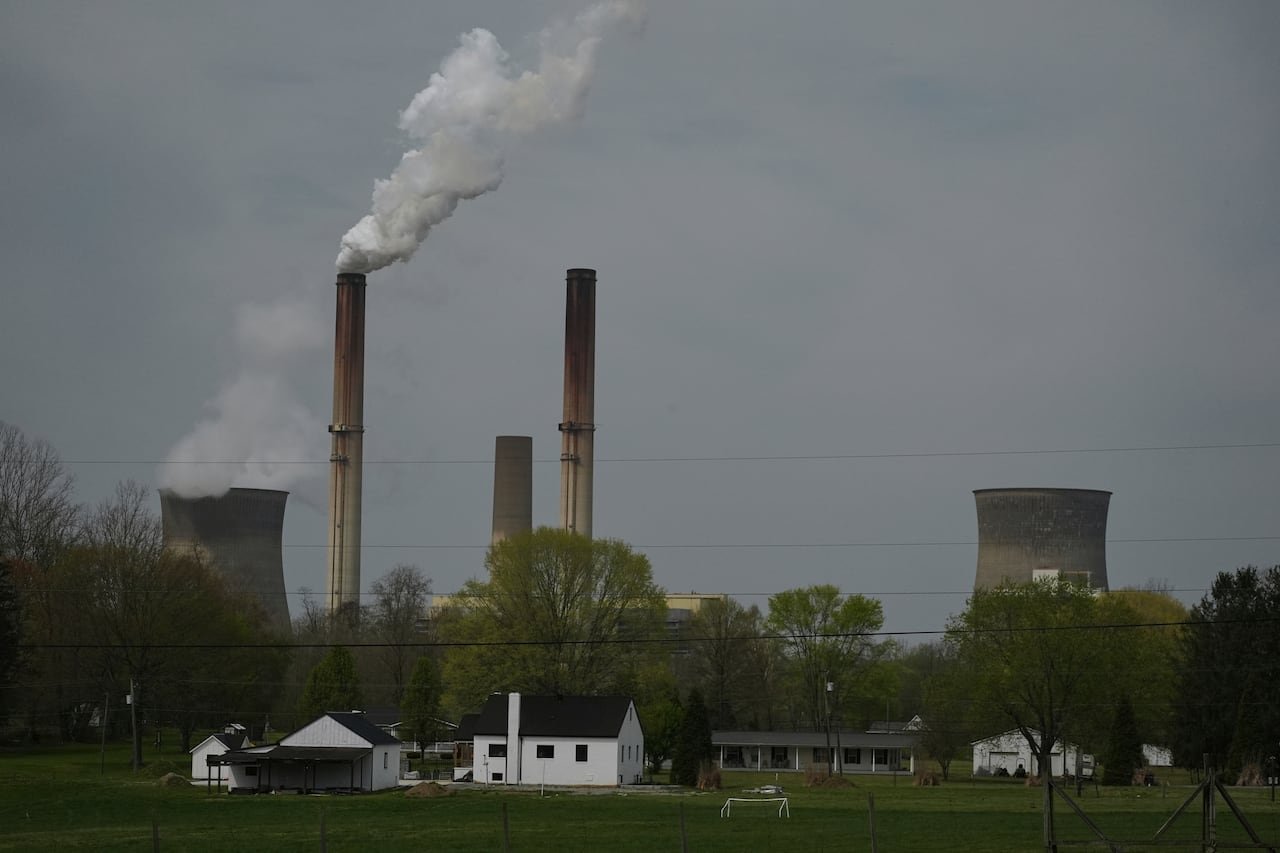 Smoke stacks spew clouds of white above a home