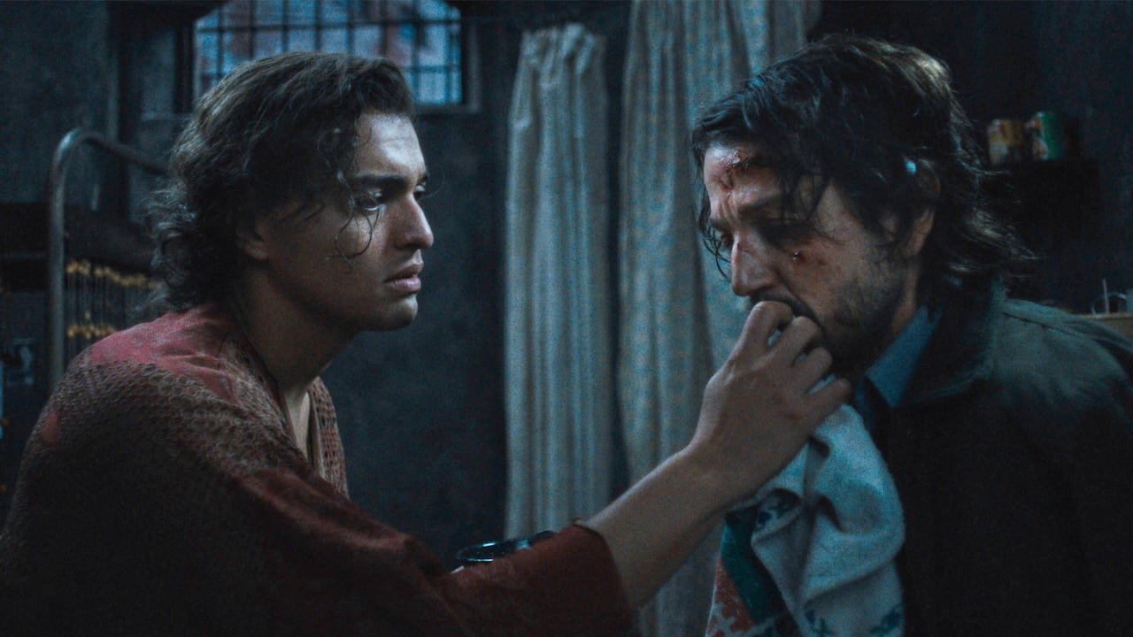 A man presses a cloth to a bleeding man's face.