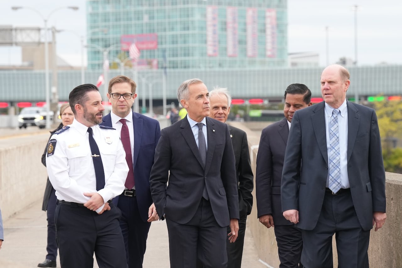 A group of government officials and border staff walk at the Rainbow Bridge border crossing.