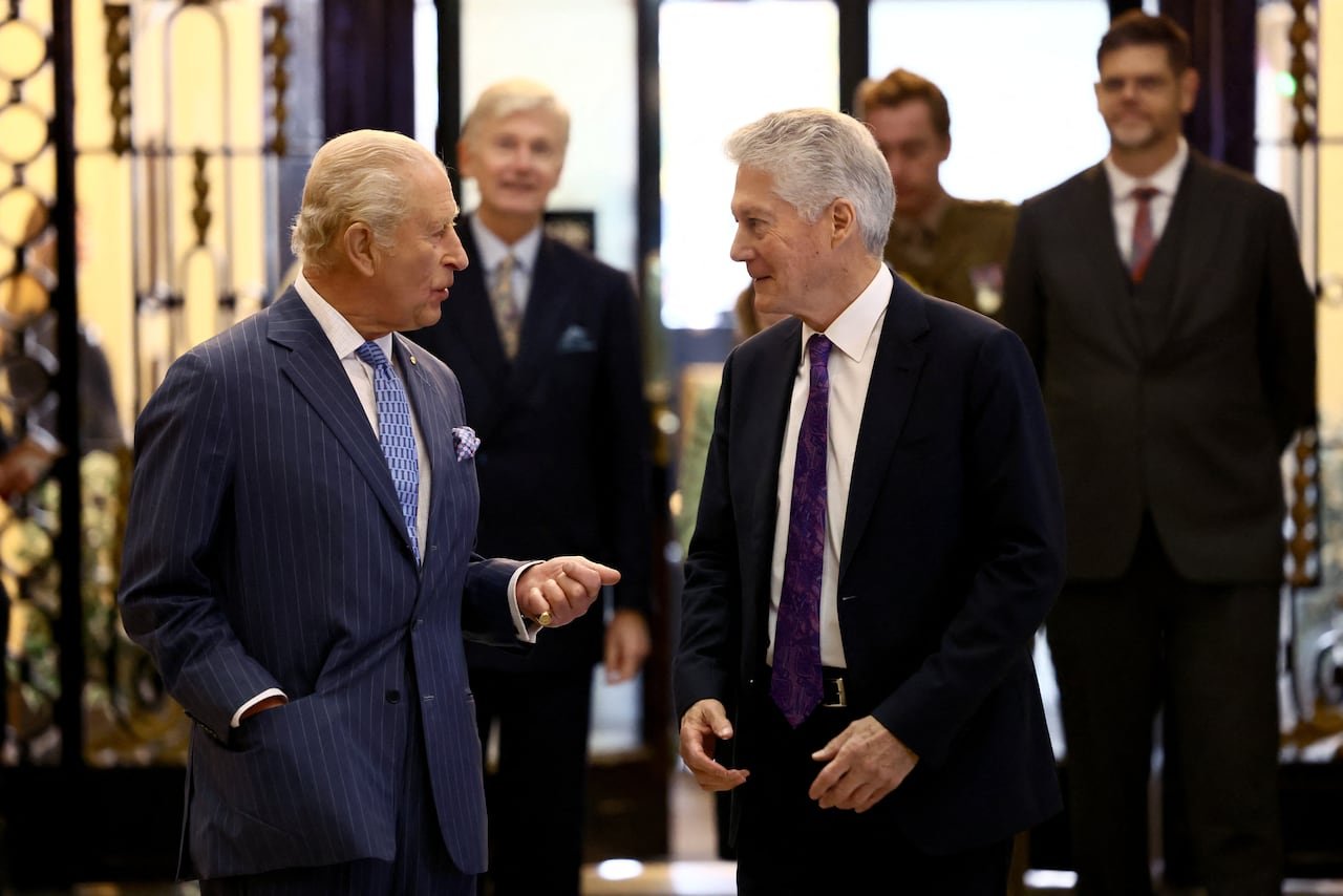 Two people stand talking to one another.