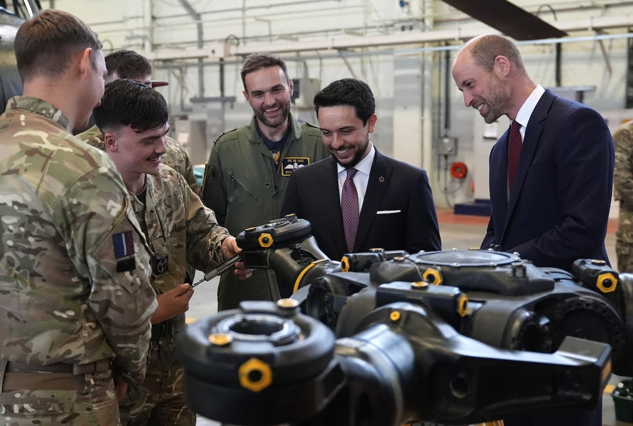 People stand looking at aircraft parts.