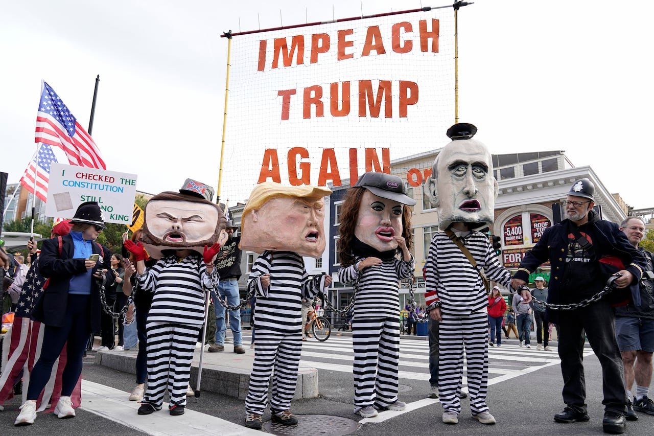 Demonstrators are seen wearing cartoonish costumes of several Trump administration officials.