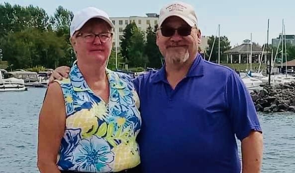 Brenda and Dan Paige standing in front of an ocean