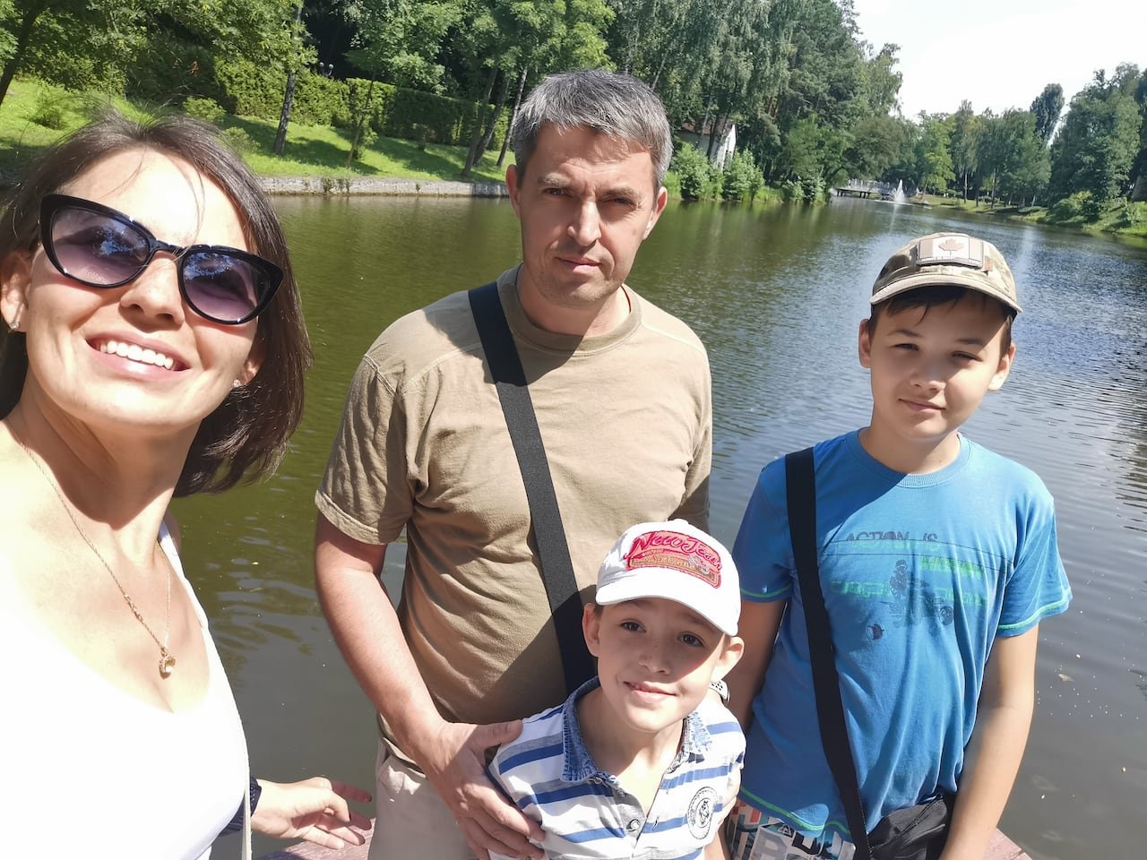 A family of four pose in front of a pond in Ukraine.