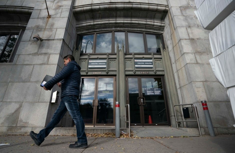 A man walks by a building with a sign that reads "Immigration, Refugees and Citizenship Canada."
