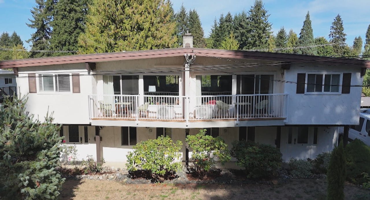 A two-storey building with white rail balconies